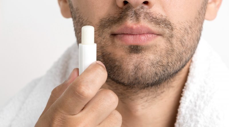 Lose Up Man With Towel Around His Neck Holding Lip Balm