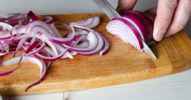 Man Cuts Red Onions Wooden Chopping Board