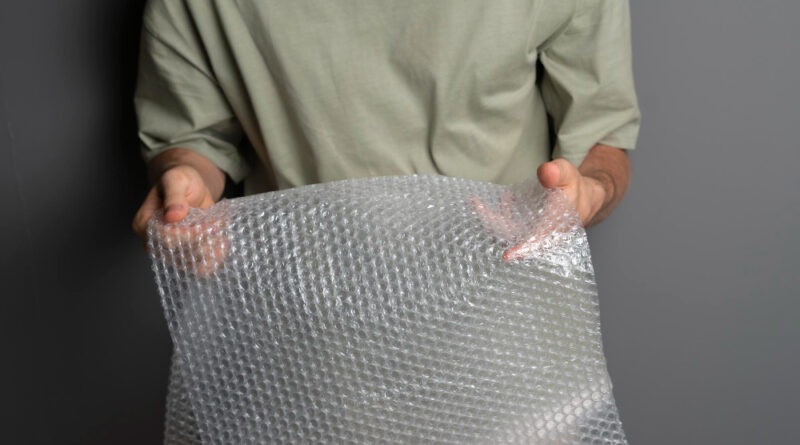 Person Holding Bursting Bubble Protective Wrap Trying Calm Down