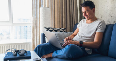 young-attractive-man-sitting-sofa-home-working-laptop-online-using-internet