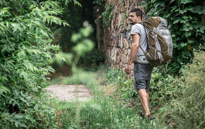 man-hike-with-large-backpack-travels-forest