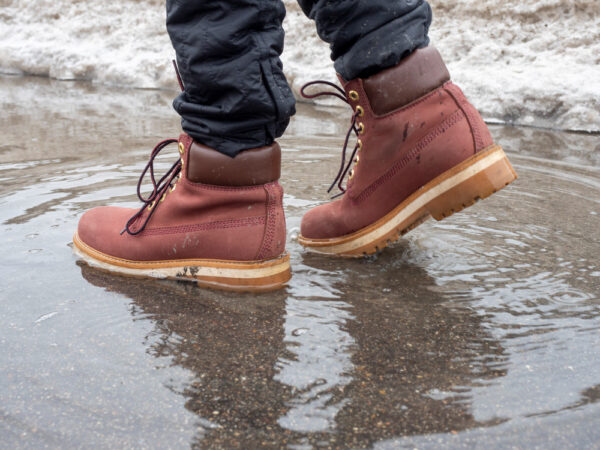 man-walks-through-puddle-terracotta-leather-shoes-close-up-reflection-puddle-littered-horizon-walking-man-concept-journey-side-view