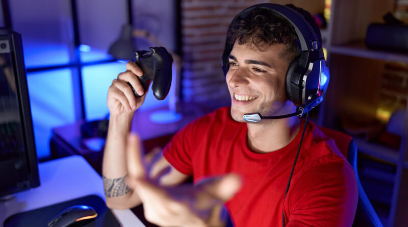 Young Hispanic Man Streamer Playing Video Game Using Joystick Gaming Room