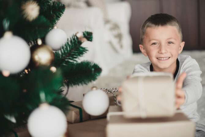 boy-showing-christmas-present-camera