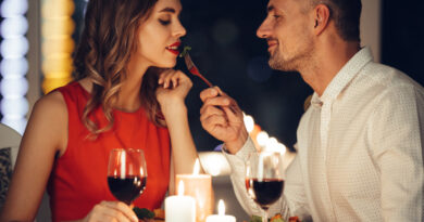 Smiling Careful Man Feed His Pretty Woman Friend While Have Romantic Dinner Home