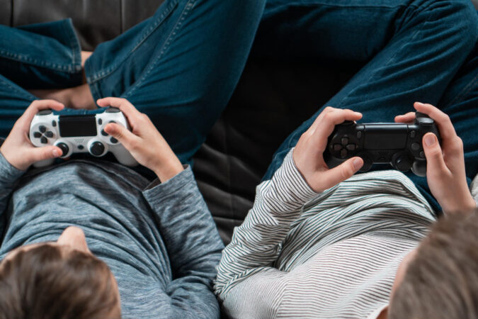 hands-guys-sitting-sofa-with-game-joysticks-from-view-kids-denim-longsleeves-play-videogames
