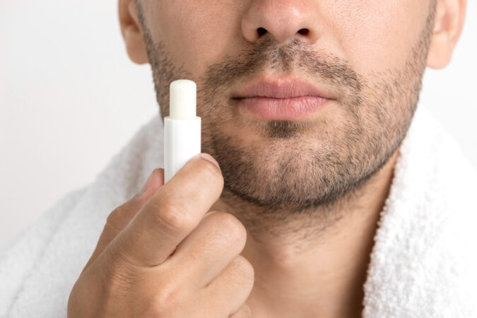 lose-up-man-with-towel-around-his-neck-holding-lip-balm