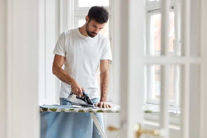 shot-responsible-husband-single-man-busy-with-house-work-irones-his-shirt-morning-ironing-desk-before-work