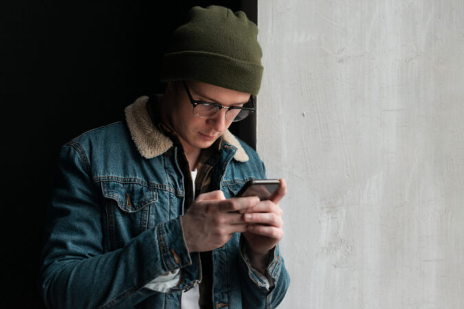 young-man-looking-his-phone-with-copy-space