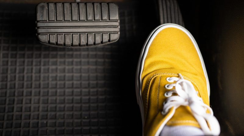Man yellow sneakers is stepping accelerator car