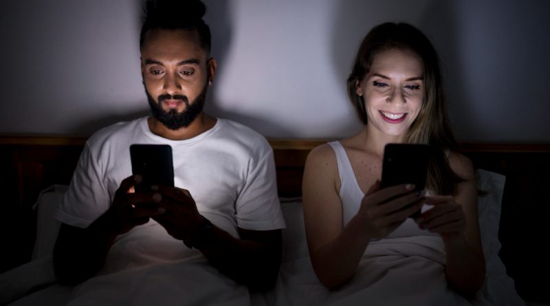 Man Woman Checking Their Phone Before Sleeping