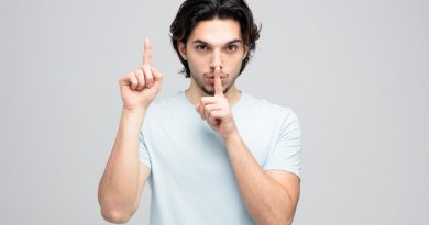 Serious Young Handsome Man Looking Camera Showing Silence Gesture Pointing Up Isolated White Background