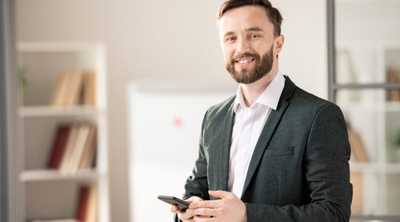 Happy young smiling manager agent with smartphone