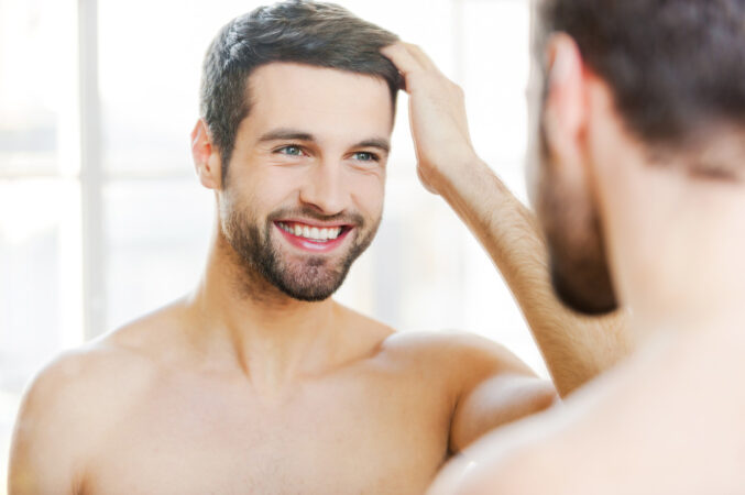 Starting New Day With Smile Handsome Young Man Touching His Hair With Hand Smiling While Standing Front Mirror