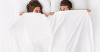 close-up-couple-lying-bed-white-blanket
