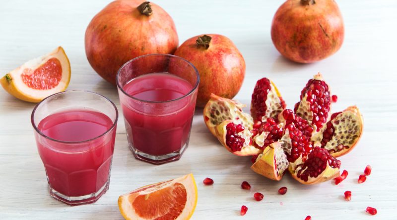Pomegranate liqueur glasses whore pomegranates wooden table