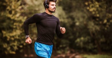 Young Male Athlete Having A Morning Jogging Next To The River.