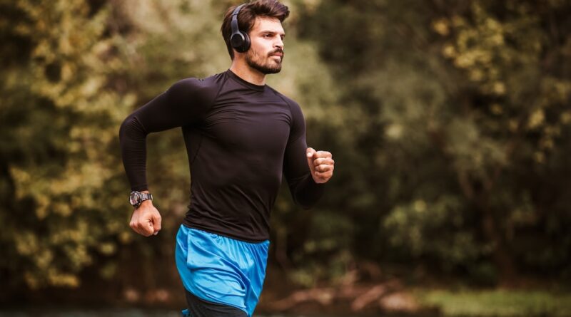 Young Male Athlete Having A Morning Jogging Next To The River.