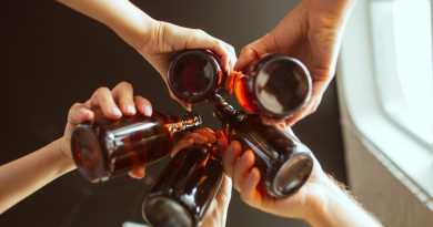 close-up-clinking-young-group-friends-drinking-beer-having-fun-laughing-celebrating-together