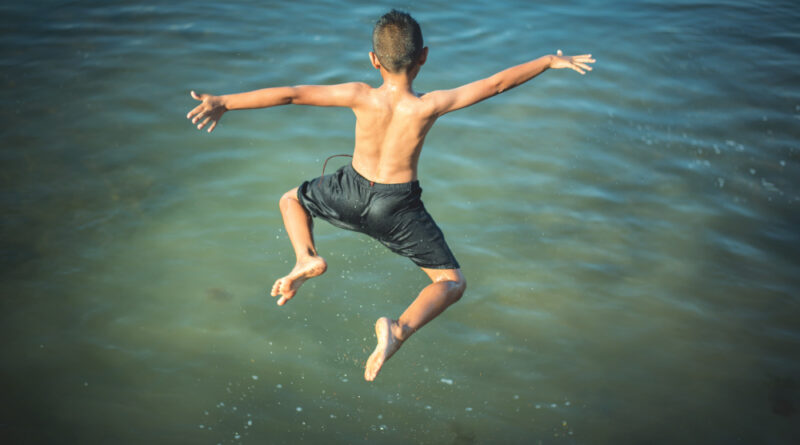 Active Boy Jumping Into Water