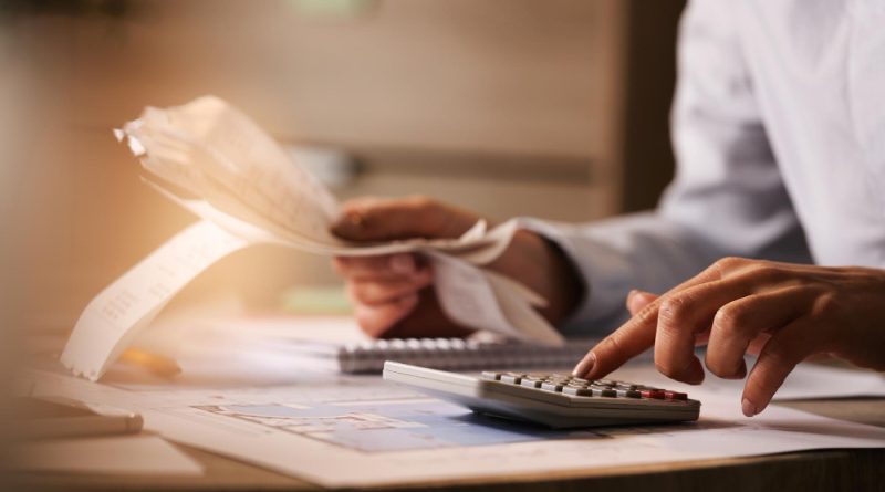 Closeup Economist Using Calculator While Going Through Bills Taxes Office