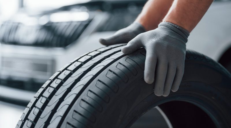 hands-only-mechanic-holding-tire-repair-garage-replacement-winter-summer-tires