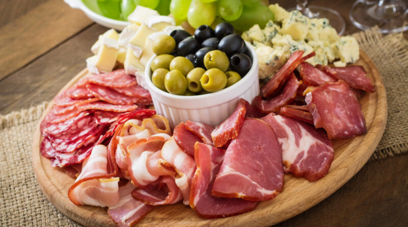 Antipasto Catering Platter With Bacon Jerky Salami Cheese Grapes Wooden Table