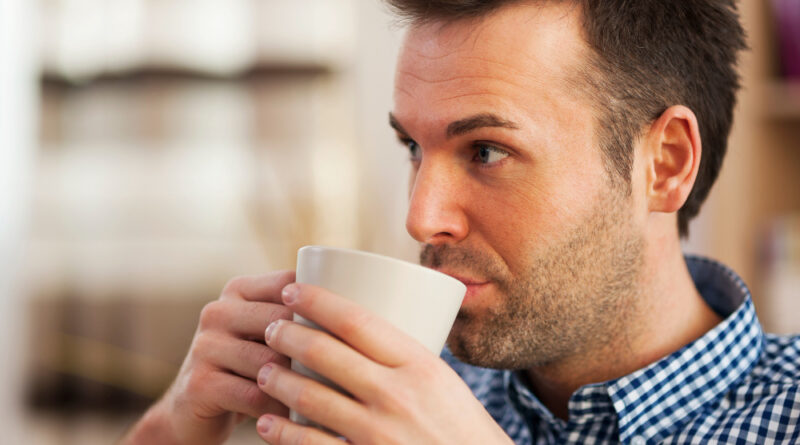 Close up man drinking coffee home