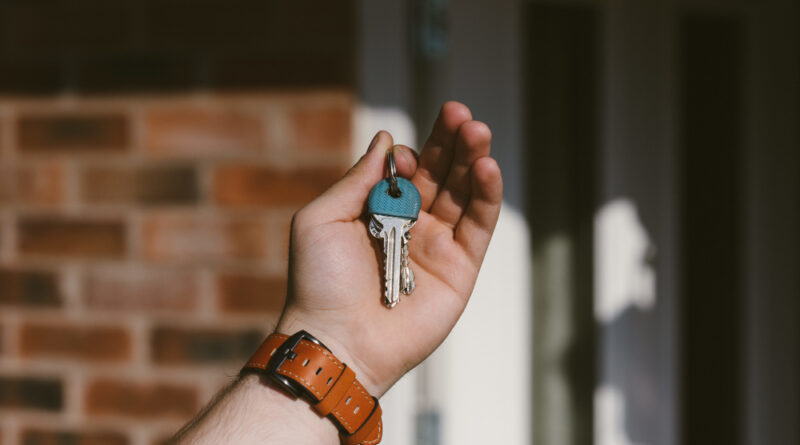 Closeup person hand holding keys with blurred background