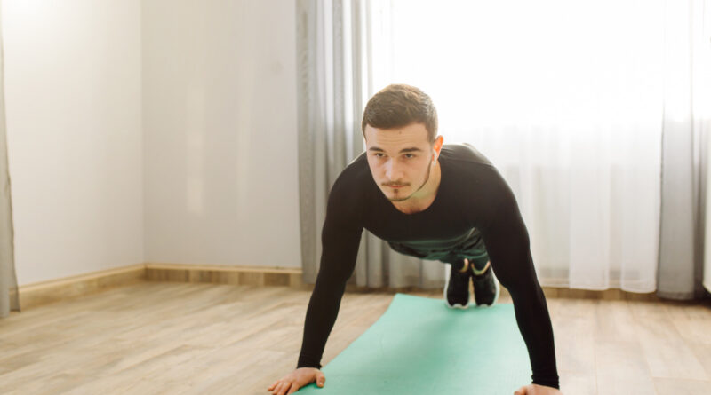 young-man-making-sport-exercises-home