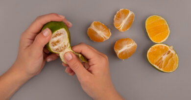 top-view-female-hand-peeling-fresh-green-tangerine