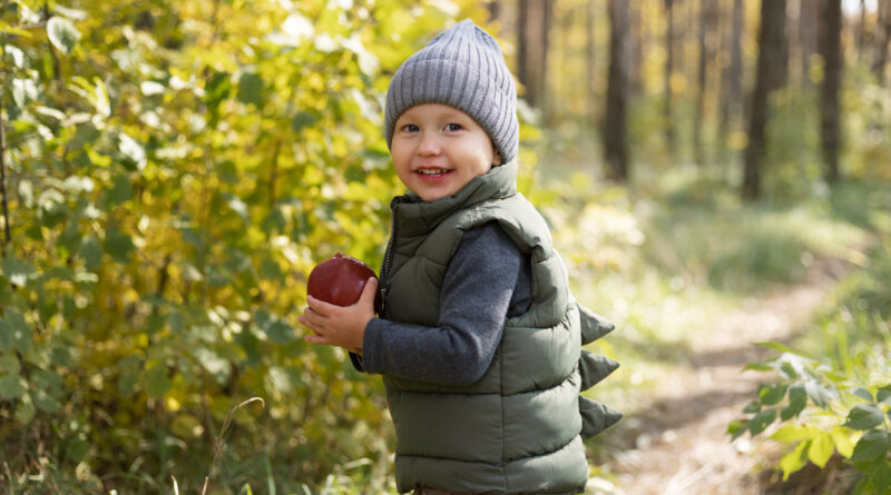 Medium Shot Smiley Kid Holding Apple