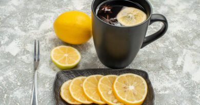 side-close-up-view-sweets-black-cup-tea-with-star-anise-lemon-fork