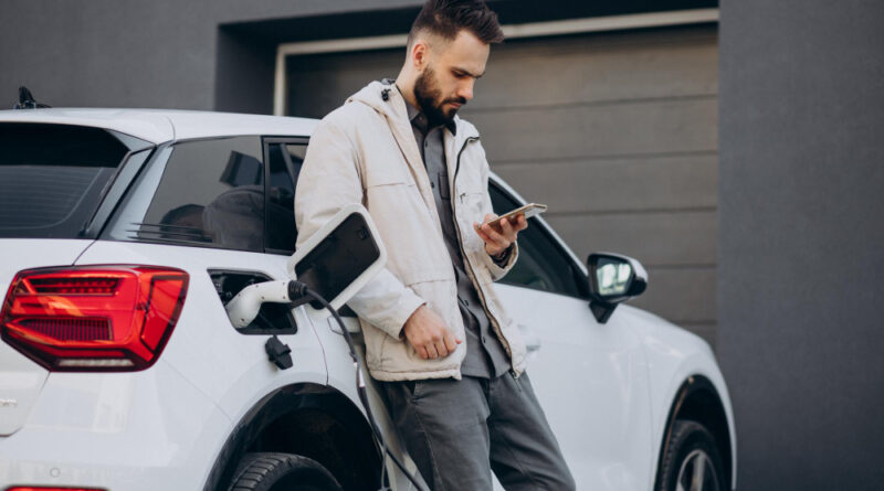 Man Charging Electric Car By House