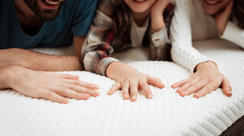 closeup-happy-family-touching-mattress-store