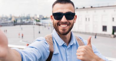 Smiling Young Man Wearing Sunglasses Taking Selfie Showing Thumb Up Gesture