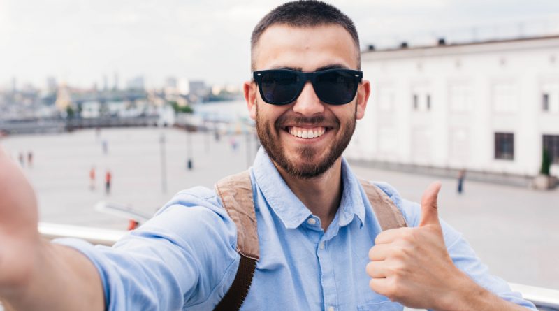 Smiling Young Man Wearing Sunglasses Taking Selfie Showing Thumb Up Gesture