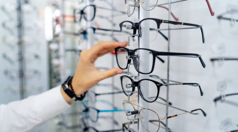 row-glasses-opticians-eyeglasses-shop-stand-with-glasses-store-optics-woman-s-hand-chooses-spectacles-eyesight-correction